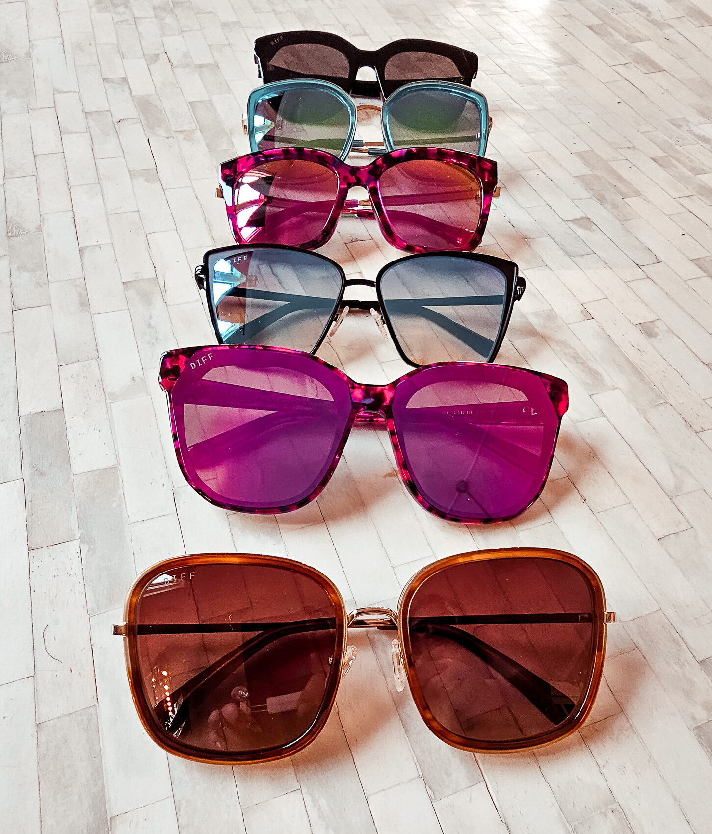 Picture of 6 Diff sunglasses we carry, the first pair is black, then blue, then pink, black again (different pair),  pink again (different pair) and then brown